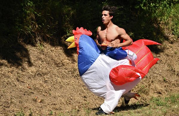 Un aficionado disfrazado de pollo corre a lo largo del recorrido de la 15ª etapa del Tour de Francia entre Rodez y Carcassonne, al sur de Francia. - Sputnik Mundo