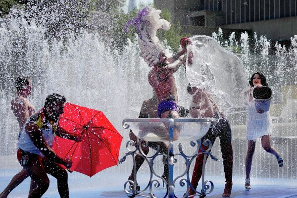 Los miembros de una compañía de circo australiana se refrescan en una fuente del distrito de Southbank, Londres.
 - Sputnik Mundo