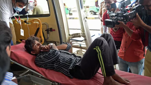 Un hombre en la ambulancia tras consumir licor espurio en el estado indio de Gujarat - Sputnik Mundo