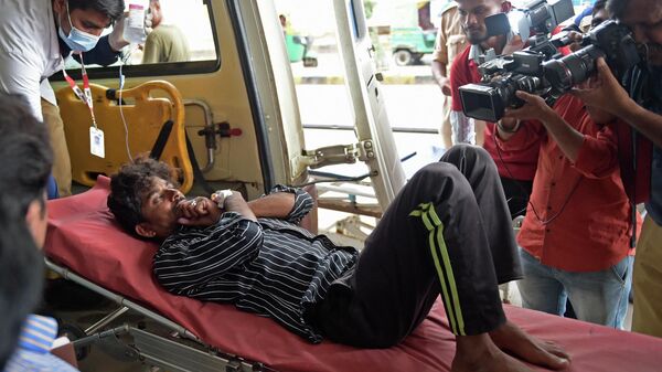 Un hombre en la ambulancia tras consumir licor espurio en el estado indio de Gujarat - Sputnik Mundo