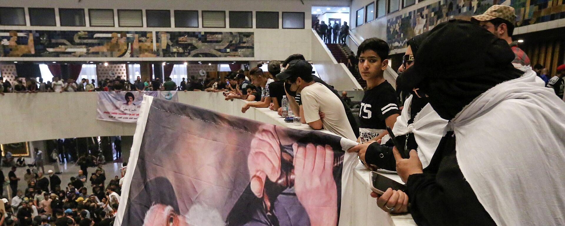 Los partidarios de Muqtada Sadr llevan un retrato del padre de Sadr, el ayatolá Mohammed Sadeq Sadr, en el interior del parlamento iraquí en la Zona Verde de alta seguridad de la capital, Bagdad, el 31 de julio de 2022, un día después de irrumpir en él. Los partidarios de Muqtada Sadr llevan un retrato del padre de Sadr, el ayatolá Mohammed Sadeq Sadr, en el interior del parlamento iraquí en la Zona Verde de alta seguridad de la capital, Bagdad, el 31 de julio de 2022, un día después de irrumpir en él. - Sputnik Mundo, 1920, 01.08.2022