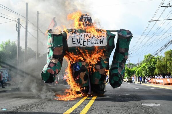 Un gorila en llamas con un cartel que dice "estado de excepción" se ve durante una manifestación que conmemora el 47 aniversario de la masacre de estudiantes universitarios el 30 de julio de 1975 en San Salvador. 30 de julio de 2022. - Sputnik Mundo
