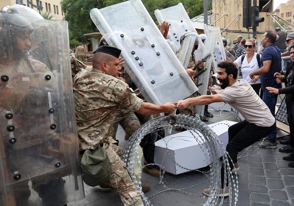 Activistas libaneses se enfrentan a los soldados que vigilan la entrada del edificio del Parlamento del país. Los disturbios se producen durante una manifestación en el centro de la capital el 4 de agosto de 2022, cuando se cumple dos años desde que una gigantesca explosión arrasó Beirut.El 4 de agosto de 2020 la explosión de nitrato de amonio almacenado al azar, una de las mayores explosiones no nucleares de la historia, mató a más de 200 personas, hirió a miles y diezmó amplias zonas de la capital. - Sputnik Mundo