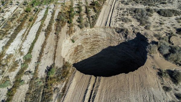 Una vista aérea tomada el 1 de agosto de 2022 muestra a un gran socavón que apareció el fin de semana cerca del pueblo minero de Tierra Amarilla, provincia de Copiapó, en el desierto de Atacama en Chile. Se levantó un perímetro de seguridad de 100 metros alrededor del agujero que apareció cerca de la mina Alcaparrosa operada por la empresa canadiense Lundin Mining. - Sputnik Mundo