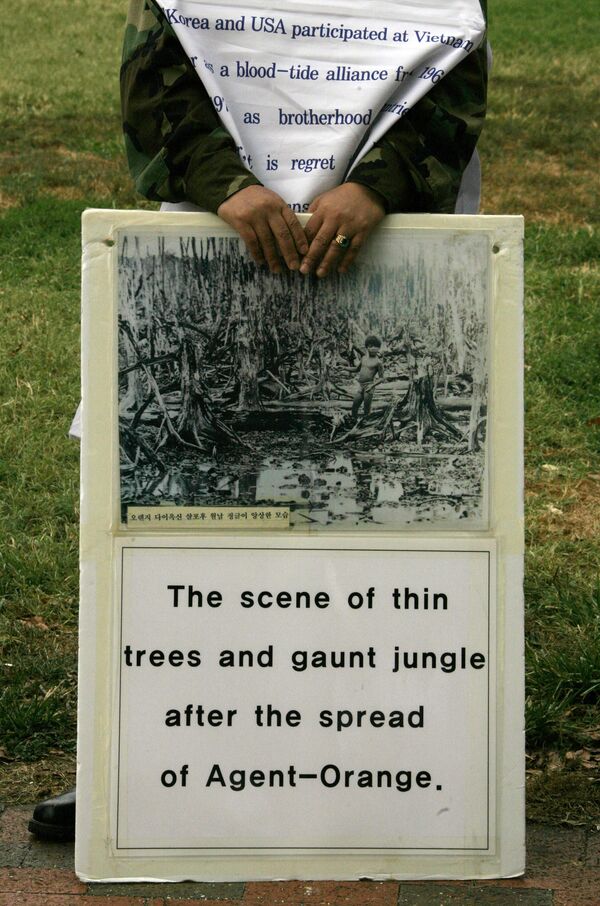 Un miembro de la Asociación de Veteranos Discapacitados de Corea sostiene una pancarta que muestra los efectos nocivos del Agente Naranja durante una protesta frente a la Casa Blanca en Washington, 2006.Los vietnamitas no fueron los únicos afectados por el Agente Naranja: también lo fueron los propios soldados estadounidenses y los que combatieron en su bando (incluidos los surcoreanos). Ahora exigen que el Gobierno estadounidense y las compañías químicas les compensen los daños. - Sputnik Mundo
