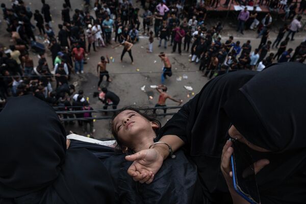 Una niña duerme en el regazo de su madre durante un ritual religioso chiíta en el Día de la Ashura en Nueva Delhi, la India. - Sputnik Mundo