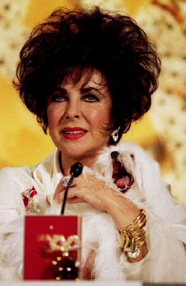 La famosa actriz estadounidense Elizabeth Taylor y su perro Sugar en una rueda de prensa para anunciar su nueva línea de perfumes Fragrant Jewel Collection, en Nueva York, 1993. - Sputnik Mundo