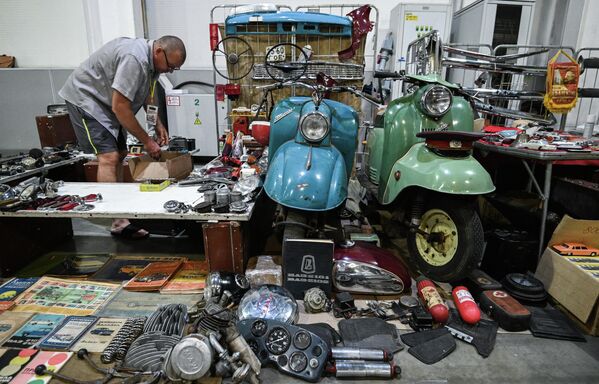 Durante los cinco días que durará el evento, el centro de exposiciones se ha convertido en una auténtica ciudad del pasado, llena de cientos de piezas únicas, desde bicicletas hasta autobuses.En la foto: uno de los participantes de la exposición prepara su estand dedicado a los autos y motos de la Unión Soviética. - Sputnik Mundo