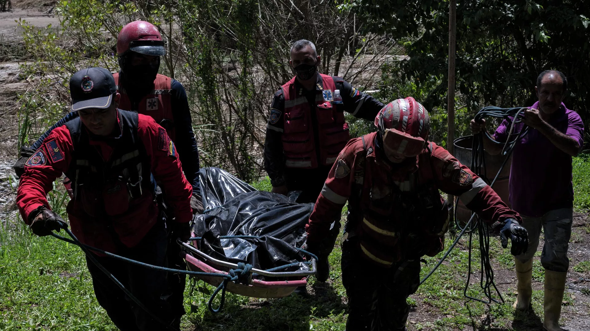 Rescatistas llevan a un hombre muerto hallado en la ribera del río Tuy días después de un derrumbe en la localidad venezolana de Las Tejerías