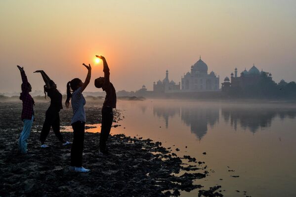 Unos niños realizan ejercicios gimnásticos al amanecer a orillas del río Yamuna, cerca del mausoleo del Taj Mahal, en Agra, al norte de la India. - Sputnik Mundo