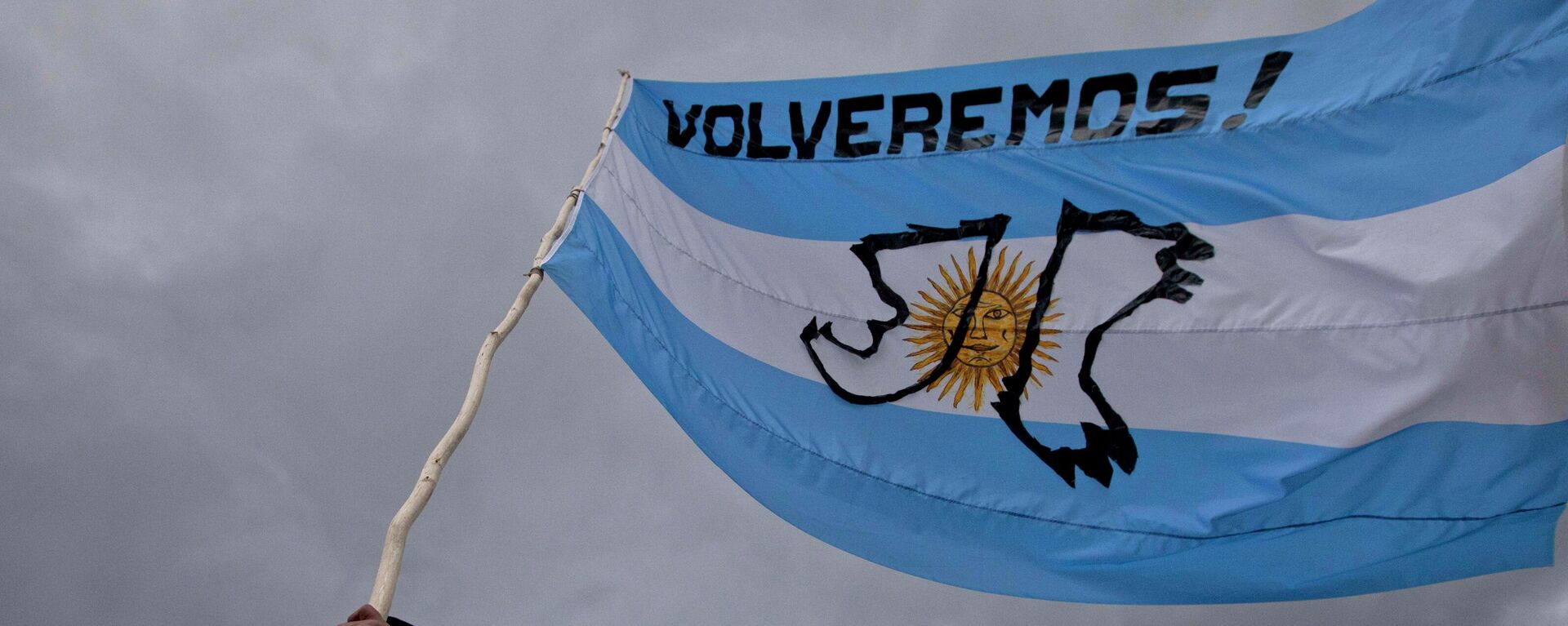 Un hombre sostiene una bandera argentina con un mensaje que dice ¡Volveremos!, durante el aniversario del conflicto de las Islas Malvinas entre el Reino Unido y Argentina - Sputnik Mundo, 1920, 02.04.2024