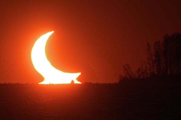 Un eclipse solar parcial, visto al atardecer cerca de Novosibirsk en Siberia Occidental, Rusia. - Sputnik Mundo