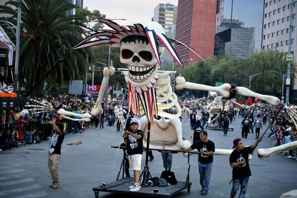 En el Día de los Muertos se cree que los espíritus visitan a los vivos. Por lo tanto, no se acostumbra a decepcionarlos. En este día, la gente cuenta historias de la vida de sus familiares fallecidos, recuerda los momentos felices que compartió con ellos y se divierte en lugar de lamentarse y llorar.En la foto: celebraciones del Día de los Muertos en Ciudad de México. - Sputnik Mundo