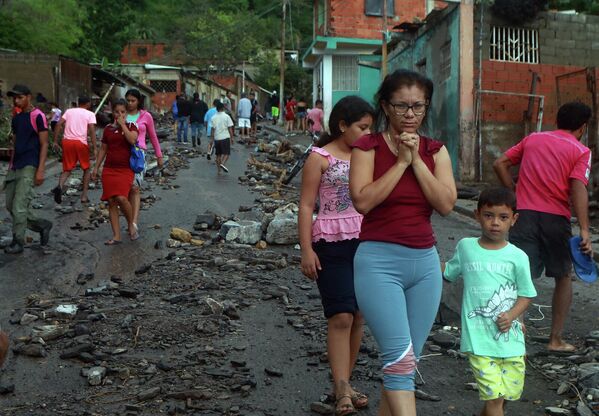 Puerto la Cruz es una ciudad portuaria de la costa caribeña de Venezuela y uno de los centros económicos más importantes. Alberga una gran refinería de petróleo. En la foto: residentes en una calle de la localidad tras el desprendimiento. - Sputnik Mundo