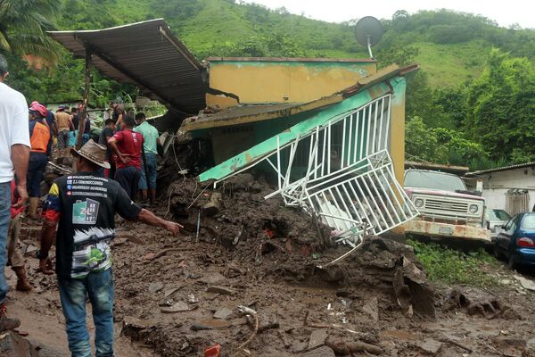 Desde el siglo XVII, cada cien años en la costa norte de Venezuela se registran inundaciones catastróficas, deslaves o corrimientos de tierra. A mediados de diciembre de 1999, los deslizamientos provocaron la muerte de 30.000 personas, dejaron 20.000 heridos y decenas de miles de personas sin hogar en el estado de Vargas, al norte de Caracas. Hace un mes, en octubre, más de 40 personas murieron a causa de los corrimientos de tierra y las inundaciones en el norte de Venezuela, y más de 800 viviendas quedaron destruidas. El país declaró tres días de luto. En la foto: las consecuencias de un desprendimiento de tierra en Puerto La Cruz. - Sputnik Mundo