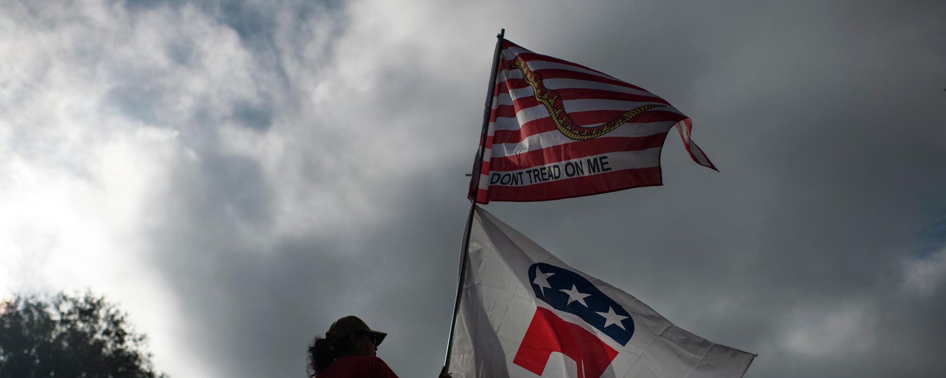 La simpatizante republicana Dolly Schultz sostiene banderas fuera de un centro de votación en el Centro Cívico SSGT Willie de Leon al inicio de la votación en Uvalde, Texas, el 8 de noviembre de 2022.  - Sputnik Mundo, 1920, 09.11.2022