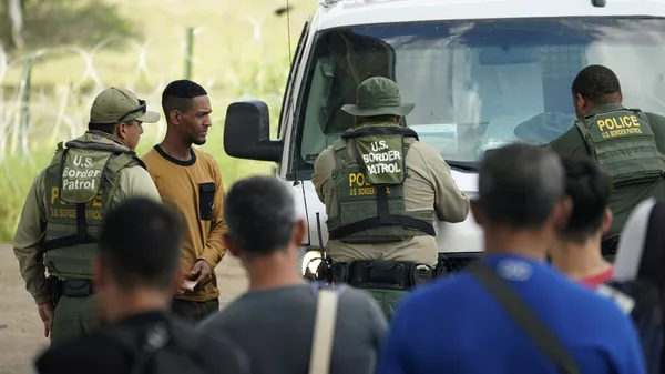 Los migrantes son procesados por la Patrulla Fronteriza después de cruzar ilegalmente el Río Grande de México a EEUU en Eagle Pass, Texas - Sputnik Mundo