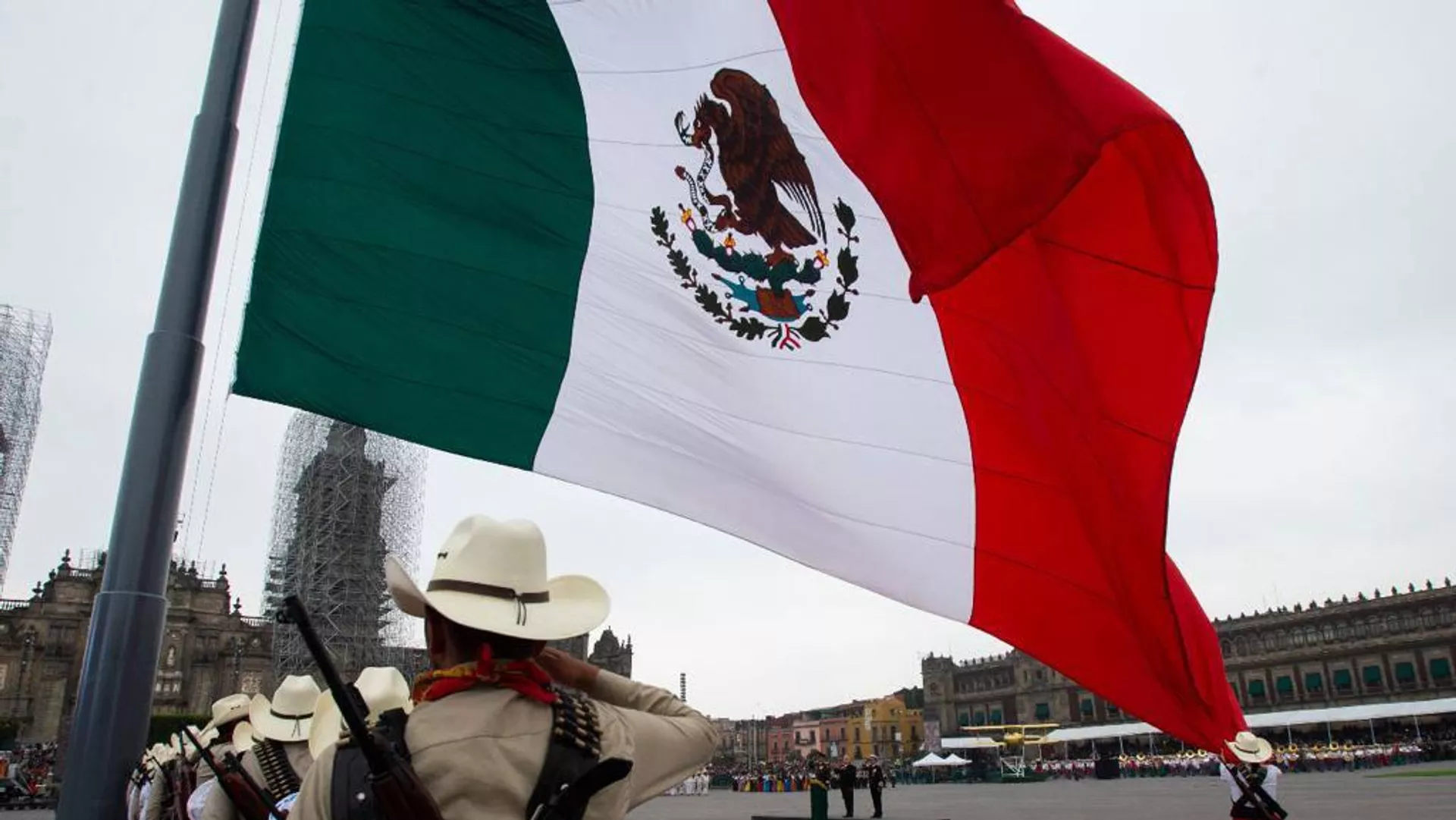Los representantes del pueblo revolucionario de inicios del siglo XX saludan a la bandera mexicana.