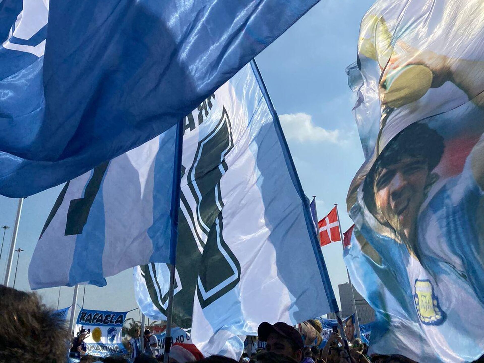 Los hinchas argentinos se reunieron portando imágenes de Diego Armando Maradona levantando la copa del mundo de 1986 - Sputnik Mundo, 1920, 25.11.2022