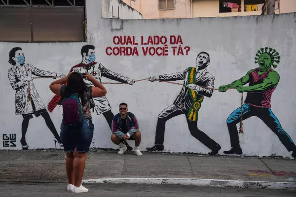 A los artistas de todas las épocas les encanta burlarse de los que están en el poder. No obstante, la caricatura política como género especial de las bellas artes se originó en la Inglaterra del siglo XVIII. Al principio, las caricaturas se publicaban en periódicos y revistas. Hoy en día, las caricaturas ocupan un lugar cada vez más prominente en el arte callejero.En la foto: grafiti del presidente saliente brasileño Jair Bolsonaro compitiendo en un tira y afloja con los médicos durante la pandemia de COVID-19. A los artistas de todas las épocas les encanta burlarse de los que están en el poder. No obstante, la caricatura política como género especial de las bellas artes se originó en la Inglaterra del siglo XVIII. Al principio, las caricaturas se publicaban en periódicos y revistas. Hoy en día, las caricaturas ocupan un lugar cada vez más prominente en el arte callejero.En la foto: grafiti del presidente saliente brasileño Jair Bolsonaro compitiendo en un tira y afloja con los médicos durante la pandemia de COVID-19. - Sputnik Mundo