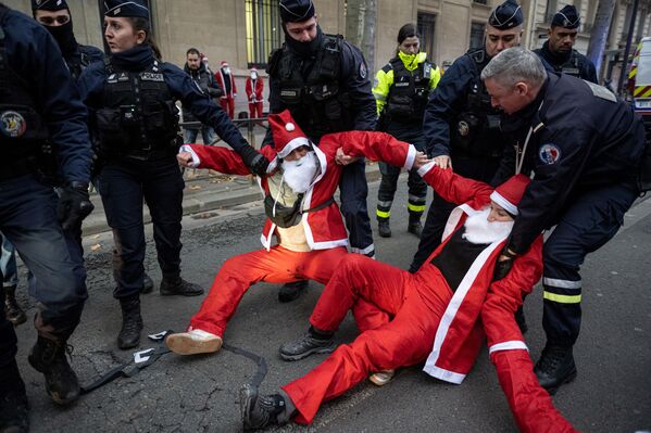 Varios agentes de la Policía detienen a los activistas del movimiento la Extinction Rebellion vestidos de Papá Noel. Los manifestantes se sentaron frente al Ministerio de Transición Ecológica en capital francesa, París, para denunciar la mala gestión medioambiental. - Sputnik Mundo