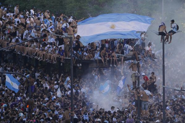 El líder y capitán de la selección argentina, Lionel Messi, ganó la Copa del Mundo por primera vez en su carrera. En la foto: los hinchas argentinos celebran la victoria de su equipo en Buenos Aires. - Sputnik Mundo