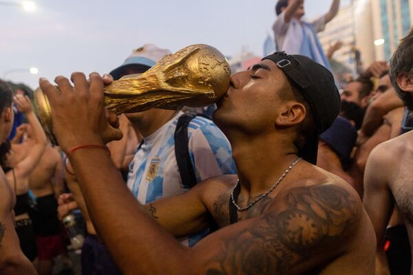 En la tanda de penaltis, Messi, Dibala, Paredes y Montiel sellaron la victoria por 4-2 para Argentina. En la foto: la emotiva celebración de los hinchas argentinos en Buenos Aires. - Sputnik Mundo