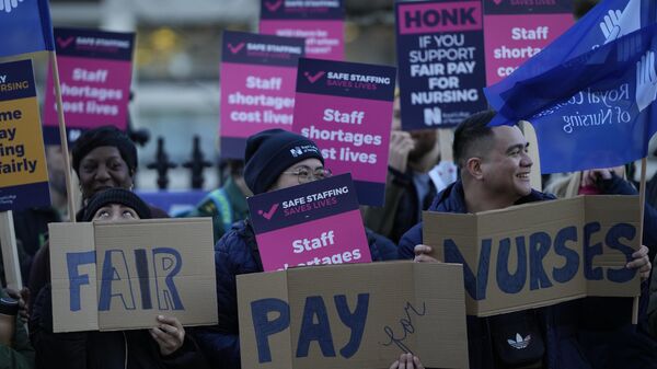 Manifestantes sostienen pancartas en apoyo a una huelga de enfermeras frente al Hospital St Thomas en Londres, 20 de diciembre de 2022.  - Sputnik Mundo