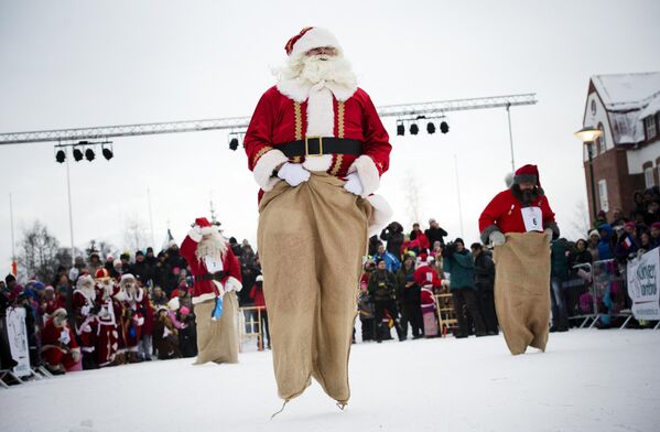 A lo largo de los años, Santa Claus cuenta con muchos copiadores en todo el mundo.De izquierda a derecha: Santa Aare de Estonia, Santa Holland de Países Bajos a, y Snaretomten de Suecia compiten en una carrera de sacos en los Juegos de Invierno de Santa Claus, en la localidad de Gallivare, al norte de Suecia. - Sputnik Mundo