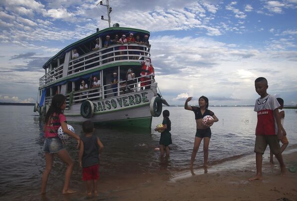 Unos niños reciben regalos de Papá Noel en una comunidad costera de Manaus, Amazonas, Brasil. - Sputnik Mundo