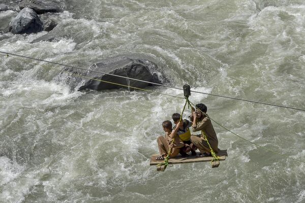 Paquistaníes usaron una polea temporal para cruzar el río Swat luego de que las fuertes lluvias lo desbordaran, el 31 de agosto. Helicópteros del Ejército de Pakistán sobrevolaron zonas aisladas por las aguas en la región montañosa del norte del país. Millones de personas quedaron atrapadas por las peores inundaciones registradas en la historia de la nación asiática.  - Sputnik Mundo