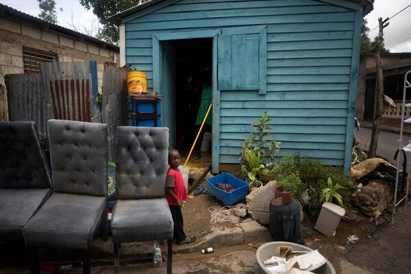 Un niño de pie fuera de su casa luego del paso del huracán Fiona en El Seibo, localidad de la República Dominicana, el 20 de septiembre.El cuerpo meteorológico produjo una lluvia torrencial en el país caribeño y produjo la muerte de una persona, además de generar amenazantes inundaciones en Puerto Rico y cortes de energía en ambas naciones. - Sputnik Mundo