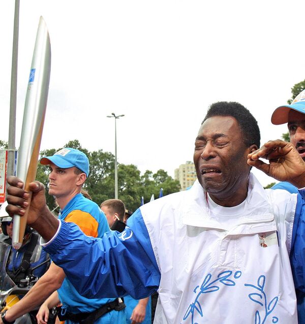 La muerte de Pelé fue anunciada por su hija Kelly Cristina Nascimento. La causa de la muerte del legendario futbolista fue un fallo orgánico debido a un cáncer avanzado.En la foto: Pelé portando la antorcha olímpica en Río de Janeiro, 2004, la primera vez que la llama pisaba suelo sudamericano. - Sputnik Mundo