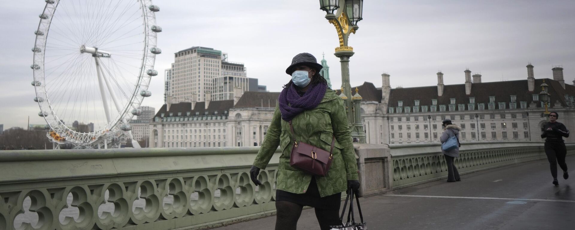 Una mujer camina sobre el puente de Westminster en Londres. - Sputnik Mundo, 1920, 21.02.2023