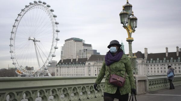 Una mujer camina sobre el puente de Westminster en Londres. - Sputnik Mundo