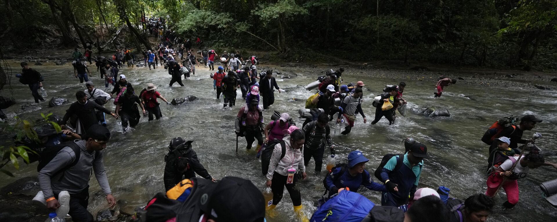 Migrantes cruzan un río durante su camino a través del Tapón del Darién desde Colombia a Panamá (archivo). - Sputnik Mundo, 1920, 17.01.2023