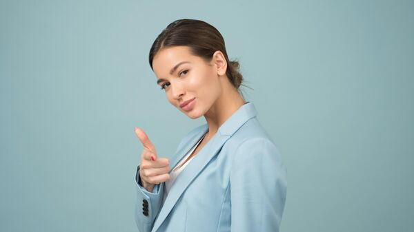 Una mujer de chaqueta azul señalando (imagen de referencia) - Sputnik Mundo