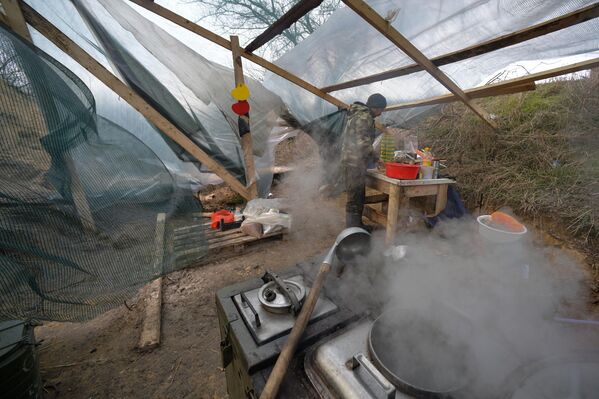 Un miembro de la brigada de infantería motorizada del Ártico prepara el almuerzo en la cocina. - Sputnik Mundo