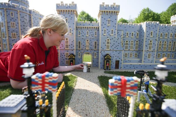 Una empleada de Legoland en Windsor, el Reino Unido, instala figuras del príncipe Harry y su prometida, la actriz estadounidense Meghan Markle, en el castillo de Windsor en vísperas de su boda. Una empleada de Legoland en Windsor, el Reino Unido, instala figuras del príncipe Harry y su prometida, la actriz estadounidense Meghan Markle, en el castillo de Windsor en vísperas de su boda. - Sputnik Mundo