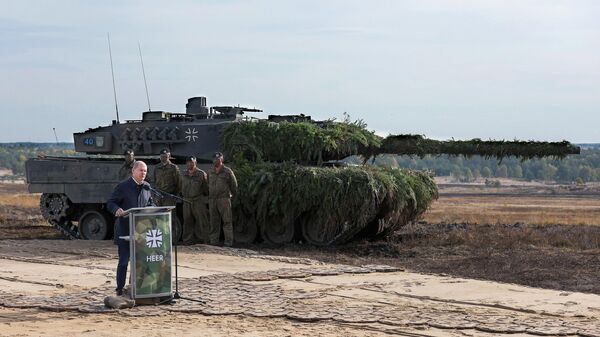 Olaf Scholz, canciller alemán, junto a un tanque de batalla Leopard 2 de las fuerzas armadas alemanas Bundeswehr - Sputnik Mundo