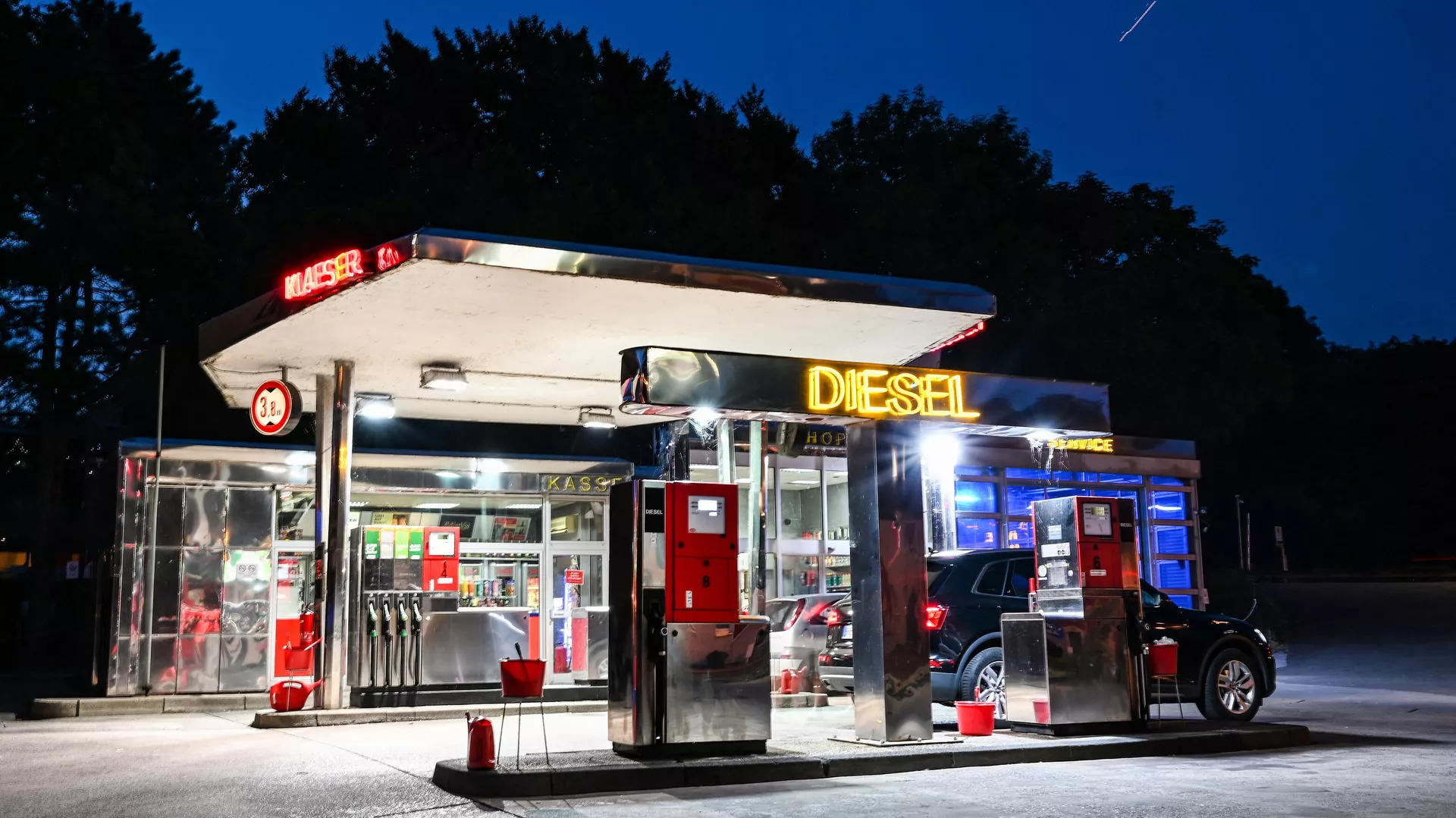 Un coche atraviesa una gasolinera con el letrero Diesel iluminado en Herten, al oeste de Alemania