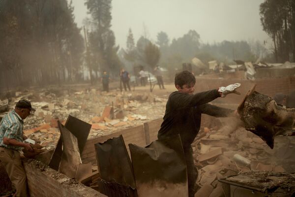 Los incendios forestales en el sur de Chile destruyeron más de 800 viviendas.En la foto: así retiran los escombros de una casa incendiada en Tome. Los incendios forestales en el sur de Chile destruyeron más de 800 viviendas.En la foto: así retiran los escombros de una casa incendiada en Tome. - Sputnik Mundo