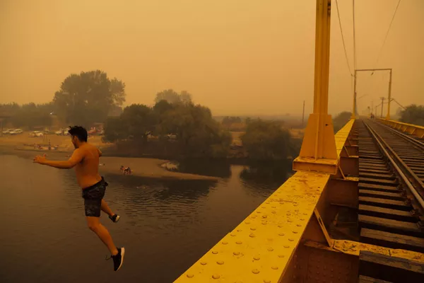 La lucha contra los incendios se ve dificultada por el denso humo que reduce enormemente la visibilidad.En la foto: un residente salta al agua en Renaico, donde los incendios forestales arrasan los alrededores. La lucha contra los incendios se ve dificultada por el denso humo que reduce enormemente la visibilidad.En la foto: un residente salta al agua en Renaico, donde los incendios forestales arrasan los alrededores. - Sputnik Mundo