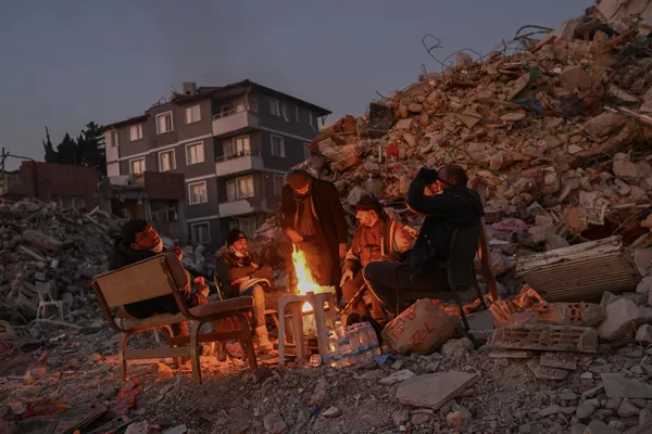 Residentes de la ciudad turca de Hatay se reúnen en torno a una hoguera cerca de un edificio de apartamentos destruido, donde sus seres queridos permanecen bajo los escombros. Residentes de la ciudad turca de Hatay se reúnen en torno a una hoguera cerca de un edificio de apartamentos destruido, donde sus seres queridos permanecen bajo los escombros. - Sputnik Mundo