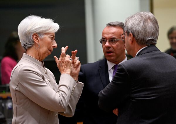 La presidenta del Banco Central Europeo, Christine Lagarde, conversa con el ministro griego de Finanzas, Christos Staikouras (centro), y el comisario europeo de Asuntos Económicos, Paolo Gentiloni, durante la reunión del Eurogrupo en Bruselas, Bélgica. - Sputnik Mundo