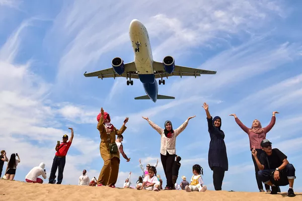 Turistas se fotografían en la playa de Mai Khao frente a un avión que se prepara para aterrizar en el aeropuerto de Phuket, Tailandia. Turistas se fotografían en la playa de Mai Khao frente a un avión que se prepara para aterrizar en el aeropuerto de Phuket, Tailandia. - Sputnik Mundo