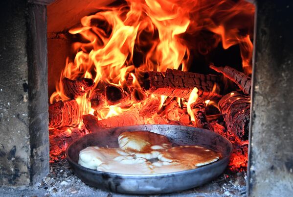 Los blinis son el principal atributo de la fiesta. Se comen con nata agria, caviar, requesón, setas y otros rellenos.En la foto: la preparación de blinis en el territorio del monasterio Bogoroditski de Kazán. - Sputnik Mundo