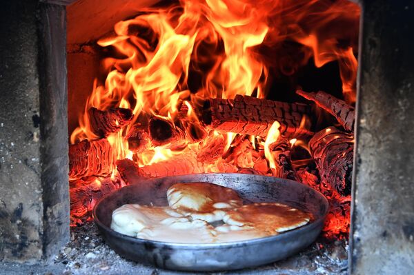 Los blinis son el principal atributo de la fiesta. Se comen con nata agria, caviar, requesón, setas y otros rellenos.En la foto: la preparación de blinis en el territorio del monasterio Bogoroditski de Kazán. - Sputnik Mundo