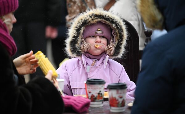 Durante la semana de la Máslenitsa se celebran actuaciones festivas por todo el país y estás van acompañadas de la preparación de platos tradicionales, entre los que destacan los blinis.En la foto: una niña come blinis en la Plaza de la Revolución de Moscú. - Sputnik Mundo