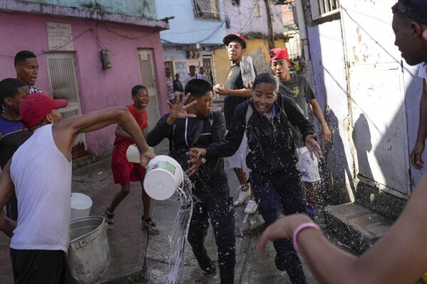 Una pareja es mojada con agua durante un carnaval en el distrito Pinto Salinas de Caracas, Venezuela. - Sputnik Mundo